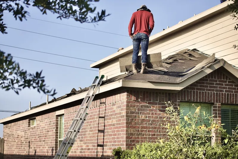 Professional roofer working on a residential roof in Concord Village
